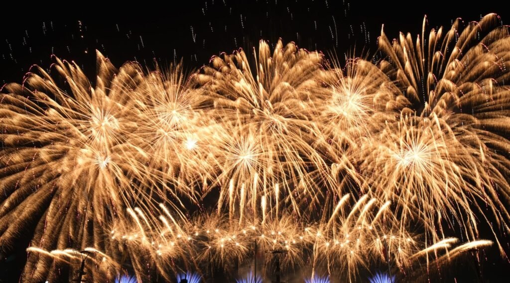 golden chrysanthemum fireworks burst over outdoor event venue